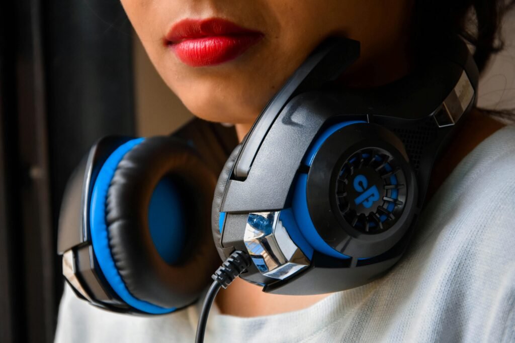 A woman wearing bold lipstick with modern black and blue headphones around her neck.